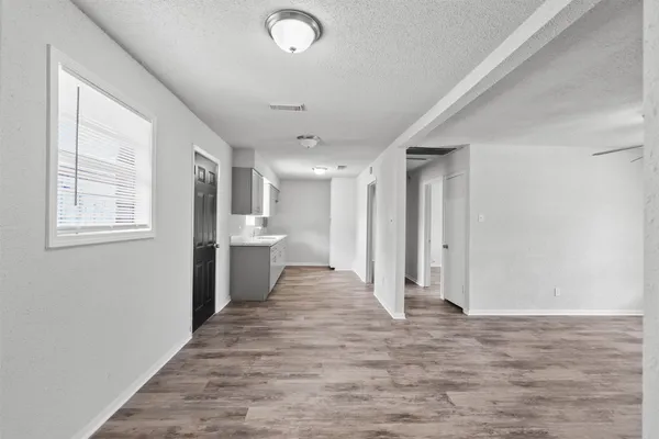 a view of a hallway with wooden floor and a window