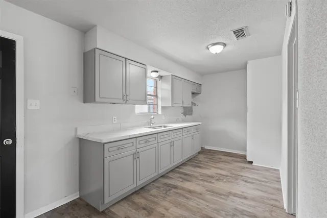 a kitchen with sink cabinets and wooden floor