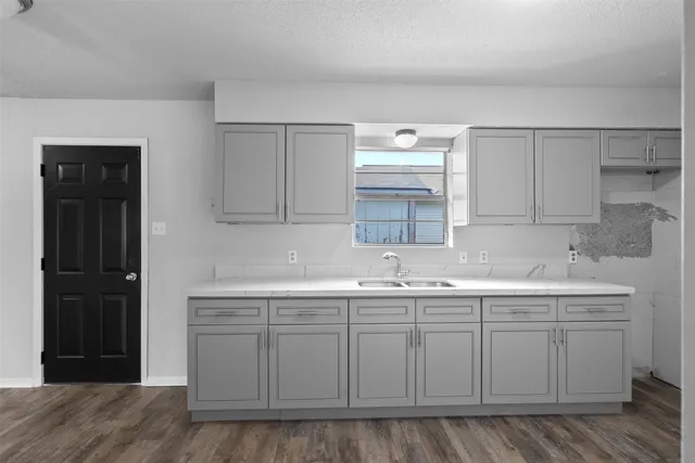 a kitchen with a sink cabinets and wooden floor