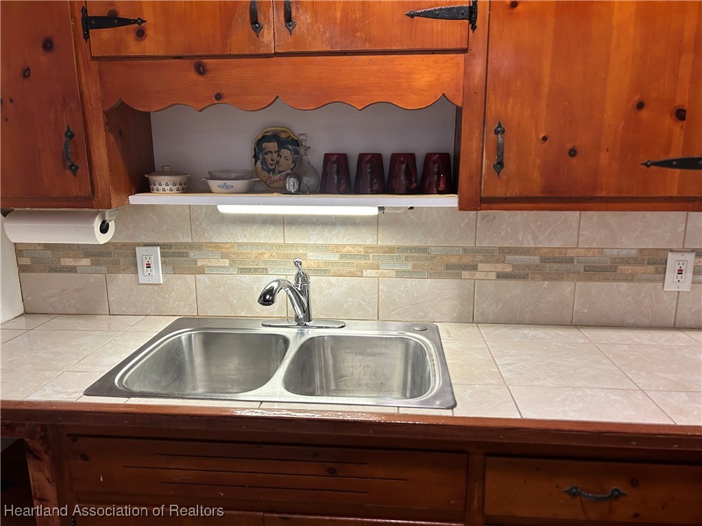 11 Mockingbird Road Lake Placid, FL 33852 - Photo 14 of 41 THE KITCHEN COUNTER AND BACKSPLASH ARE NICELY TILED COMPLIMENTING THE SOLID WOOD CABINETRY.