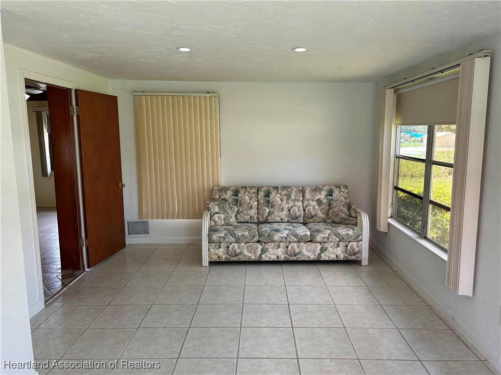 11 Mockingbird Road Lake Placid, FL 33852 - Photo 6 of 41 LIVING ROOM IS LIGHT AND BRIGHT! A SLIVER OF LAKE JUNE CAN BE SEEN FROM THIS ROOM TO ADD INTEREST. THIS ROOM COULD BE USED AS A FLORIDA ROOM OR WHATEVER YOU WOULD LIKE TO USE IT FOR!