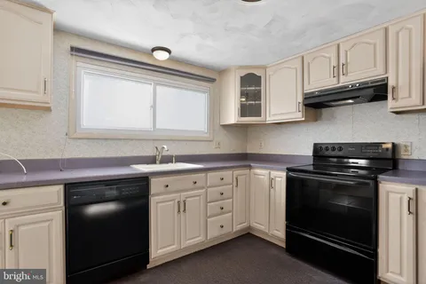 a kitchen with stainless steel appliances granite countertop a refrigerator stove and sink