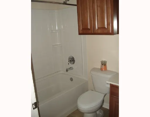 a white toilet sitting next to a bath tub