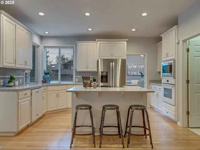 a kitchen with white cabinets and stainless steel appliances