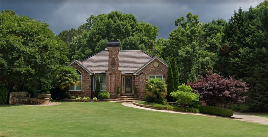 6625 Payton Road Cumming, GA 30041 - Photo 1 of 1 a front view of a house with a garden and trees