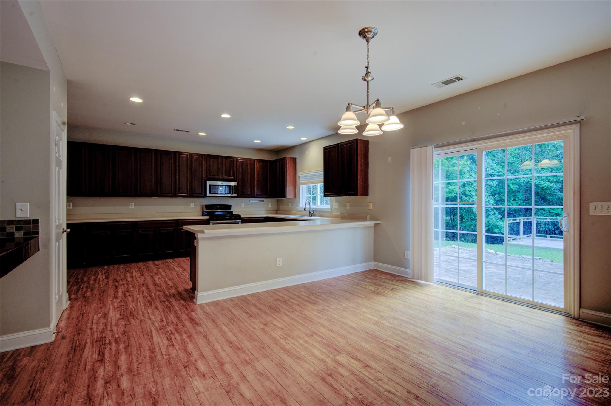 9201 Seamill Road Charlotte, NC 28278 - Photo 9 of 23 a large kitchen with granite countertop a stove and a wooden floors