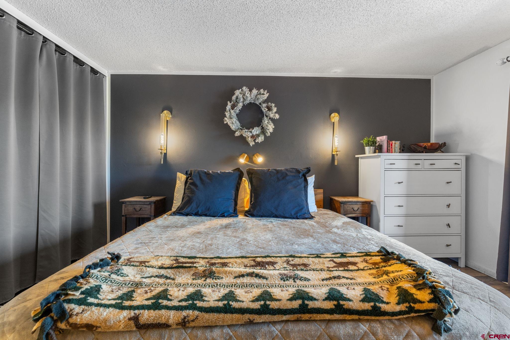 72 Hunter Hill Road, Unit I204 Crested Butte, CO 81225 - Photo 17 of 44 a bedroom with a bed and painting on the wall