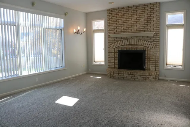 a view of an empty room with a fireplace and a window