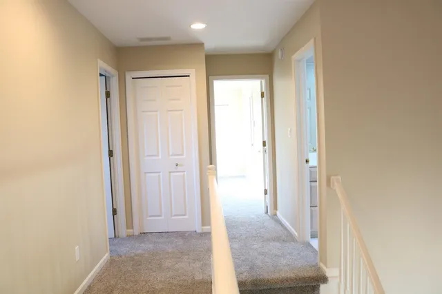 a view of a hallway with wooden shelves