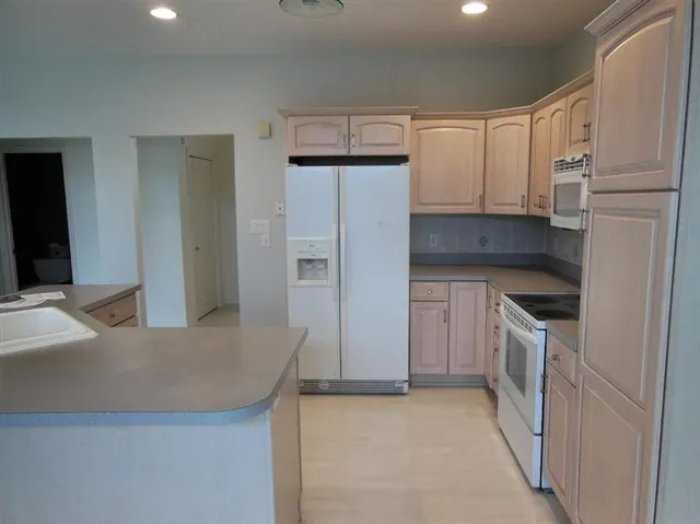 a kitchen with granite countertop a refrigerator and a sink
