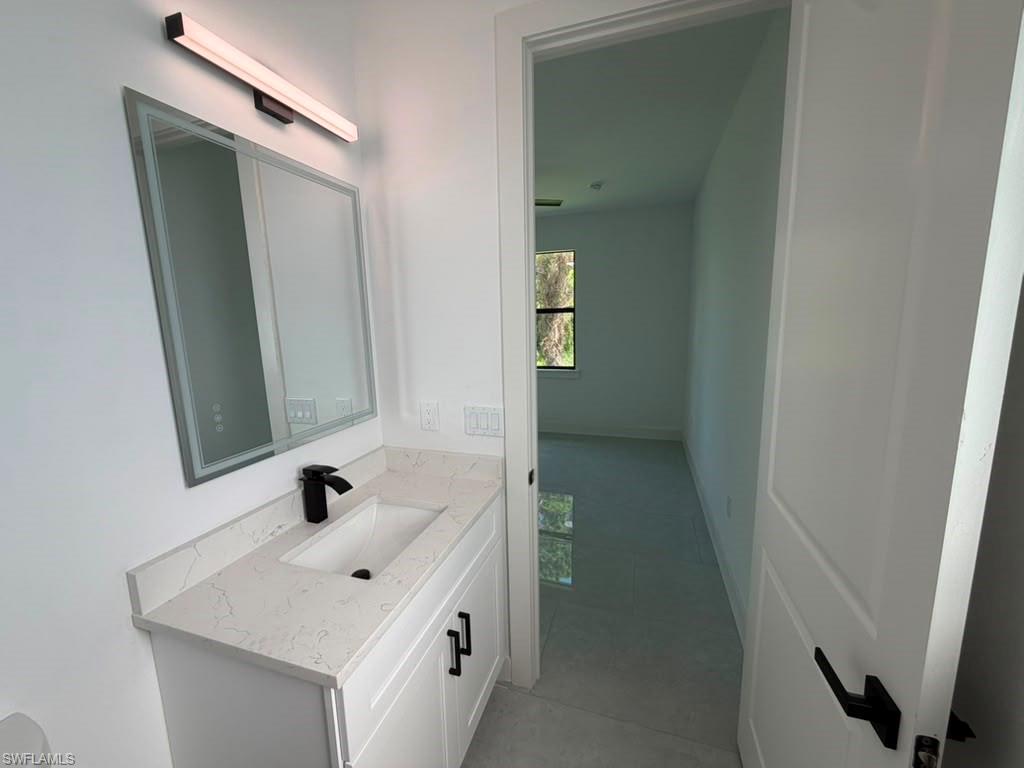 907 Homestead Road South Lehigh Acres, FL 33974 - Photo 38 of 43 Bathroom vanity featuring a quartz-finish countertop, under-mount sink, and matte black faucet