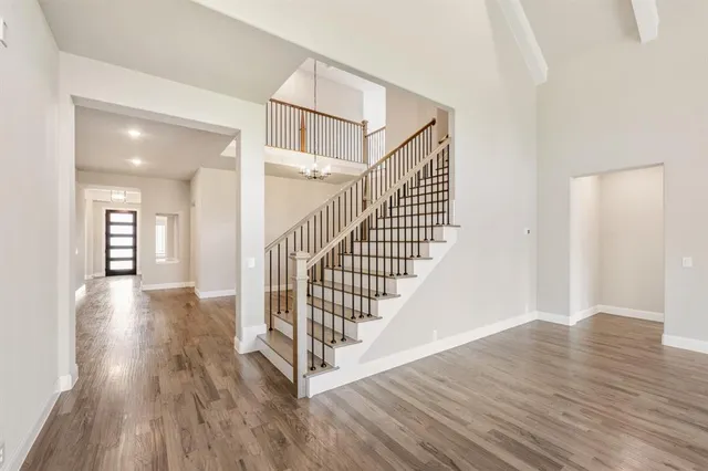 a view of a hallway with wooden floor and staircase