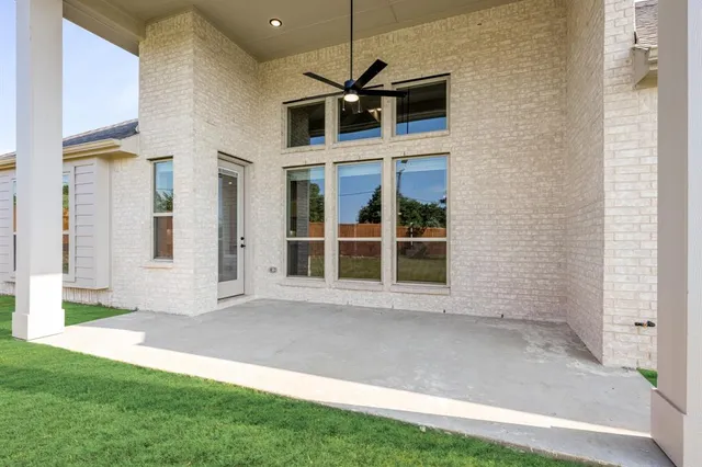 a front view of a house with a large window and potted plants