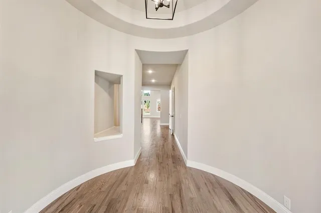 a view of a hallway with wooden floor and a mirror