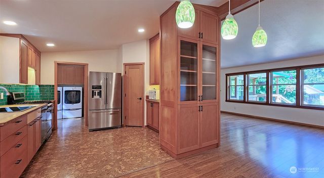 a kitchen with stainless steel appliances kitchen island granite countertop a refrigerator and a stove