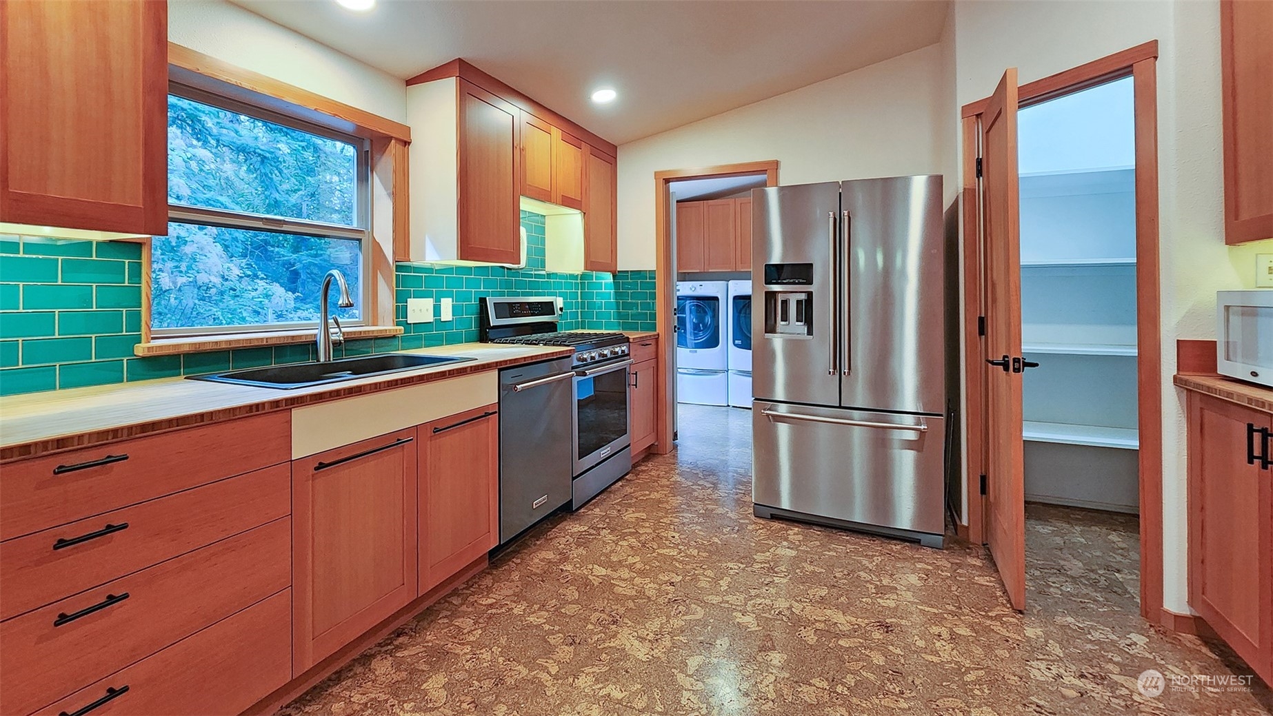 653 Shark Reef Road Lopez Island, WA 98261 - Photo 9 of 33 a kitchen with stainless steel appliances granite countertop a refrigerator a sink a stove and a window