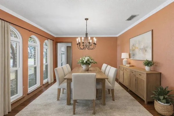 a dining room with furniture potted plants and wooden floor