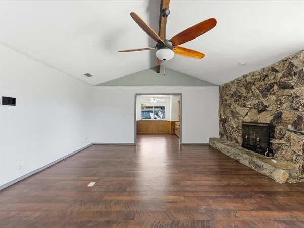 an empty room with windows and fireplace