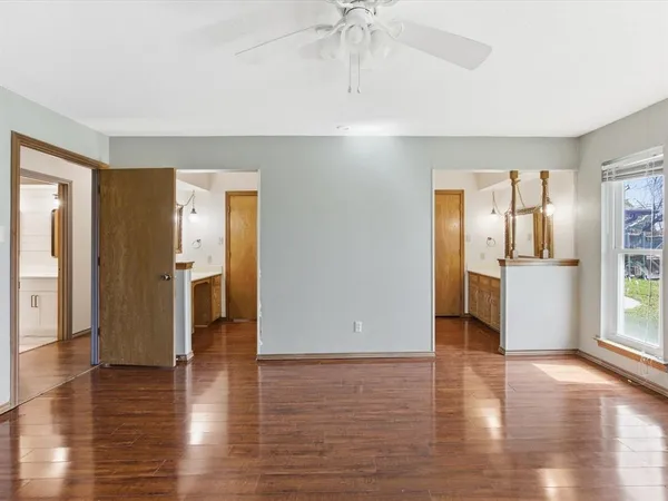 a view of a kitchen with a refrigerator a ceiling fan and wooden floor