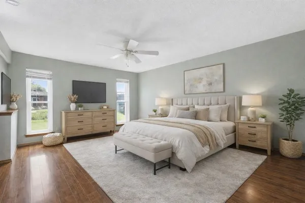 a spacious bedroom with a bed and a flat screen tv