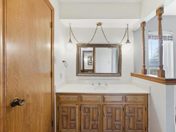 a bathroom with a sink a mirror and a window