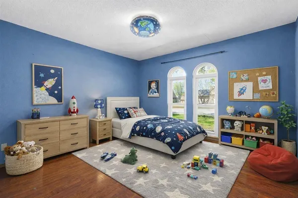 a bedroom with bed and a wooden floor