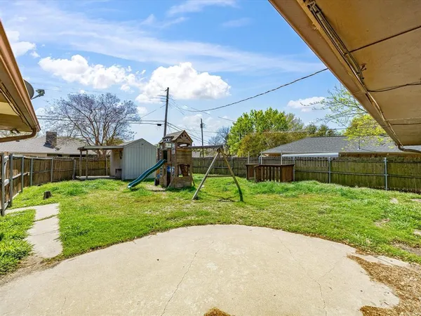 a backyard of a house with table and chairs