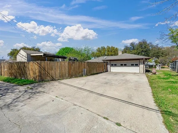 a view of a yard with wooden fence