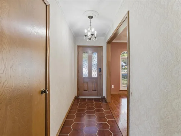 a view of a hallway with wooden floor and a bathroom