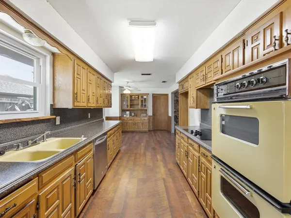 a view of a kitchen with a sink and wooden floor