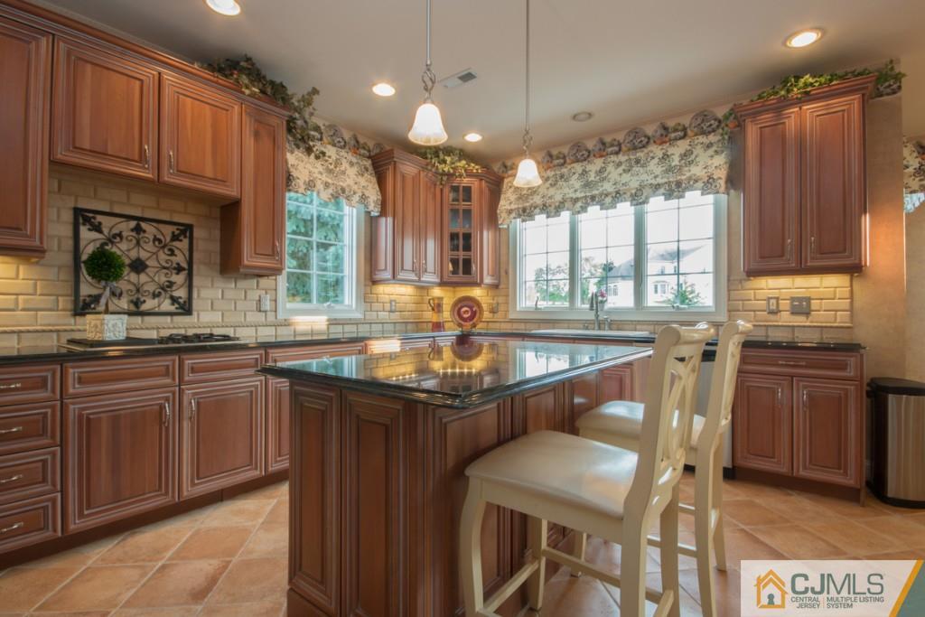 1 Baker Way Pennington, NJ 08534 - Photo 11 of 25 a kitchen with stainless steel appliances granite countertop a table chairs sink refrigerator and microwave