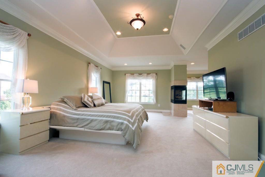1 Baker Way Pennington, NJ 08534 - Photo 18 of 25 a spacious bedroom with a large bed and a flat screen tv