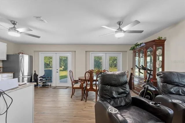 a living room with furniture chandelier and a large window