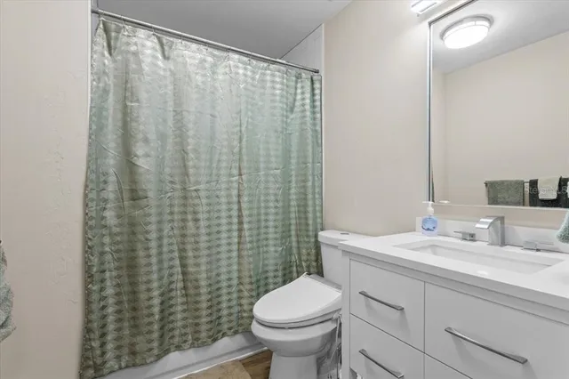 a bathroom with a sink a toilet and shower curtain