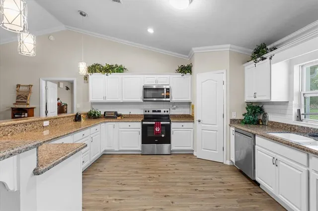 a kitchen with granite countertop a stove top oven a sink dishwasher and a refrigerator