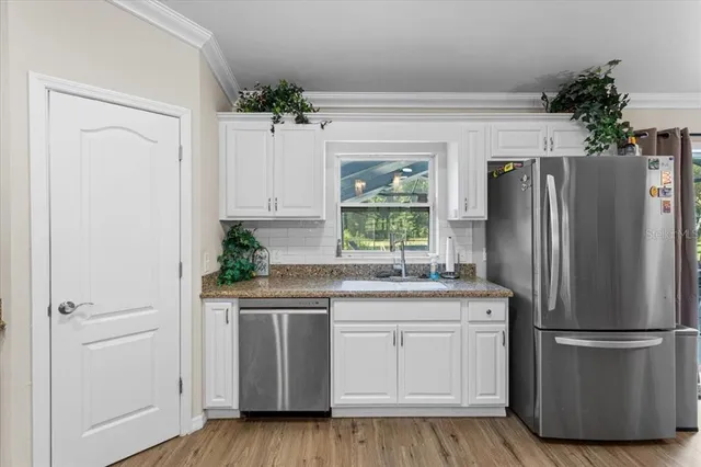 a kitchen with a refrigerator sink and cabinets