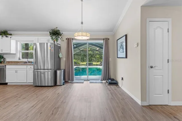 a view of kitchen with granite countertop stainless steel appliances and wooden floor