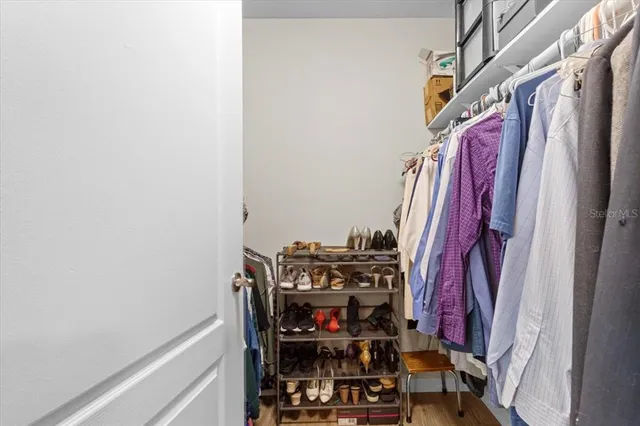 a view of walk in closet with clothes and shoes