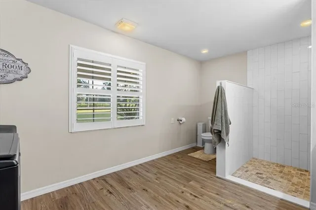 a view of a room with wooden floor and a window