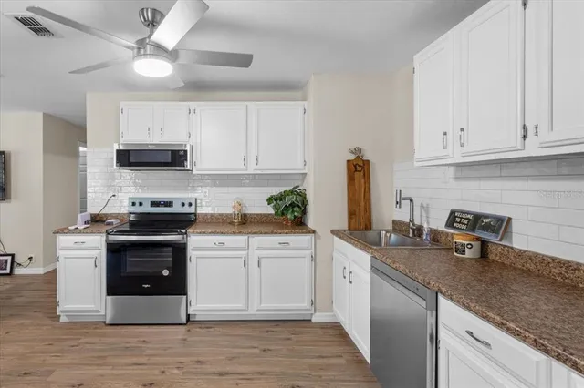 a kitchen with stainless steel appliances granite countertop a stove sink and cabinets