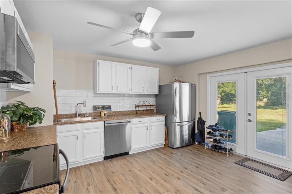 4700 Southwest Wilson Springs Road Fort White, FL 32038 - Photo 10 of 41 a kitchen with stainless steel appliances granite countertop a refrigerator a sink a stove and white cabinets