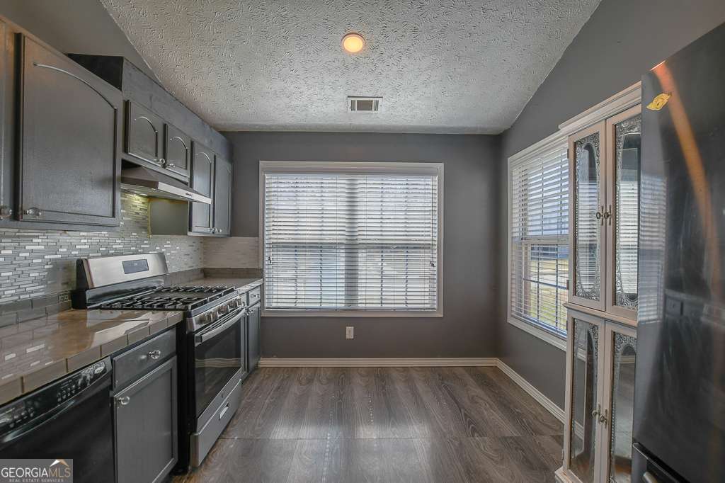 336 Shenandoah Circle Winder, GA 30680 - Photo 12 of 38 a kitchen with stainless steel appliances granite countertop a stove and a refrigerator