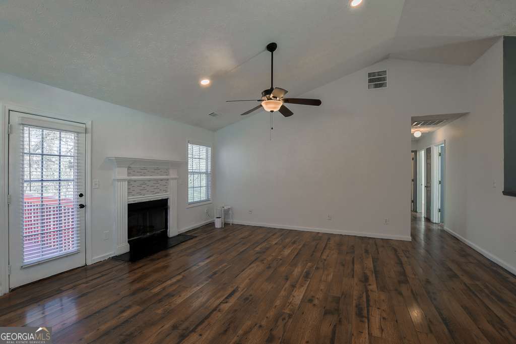 336 Shenandoah Circle Winder, GA 30680 - Photo 8 of 38 an empty room with wooden floor fireplace and windows
