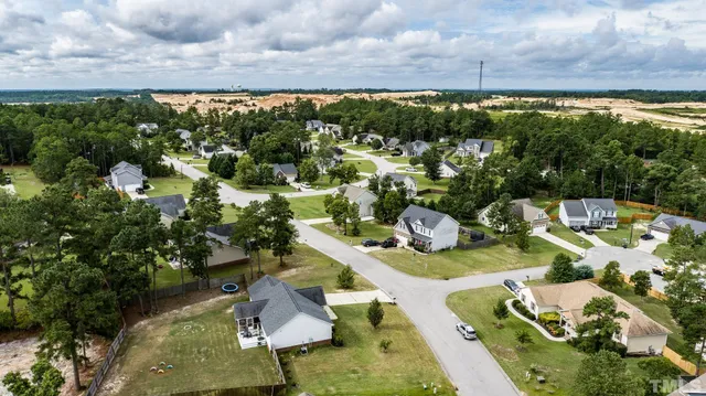 an aerial view of residential houses with outdoor space and trees