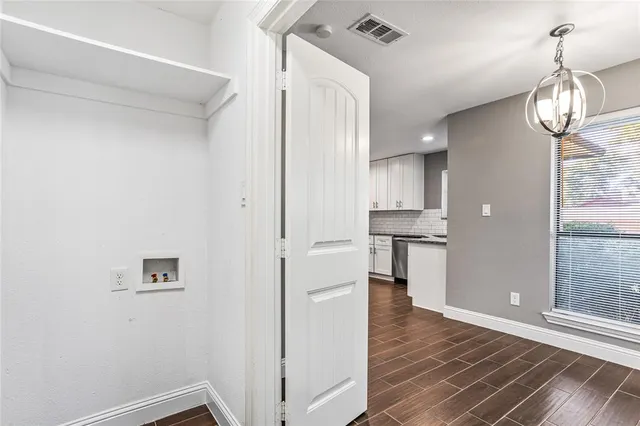 a view of empty room with wooden floor