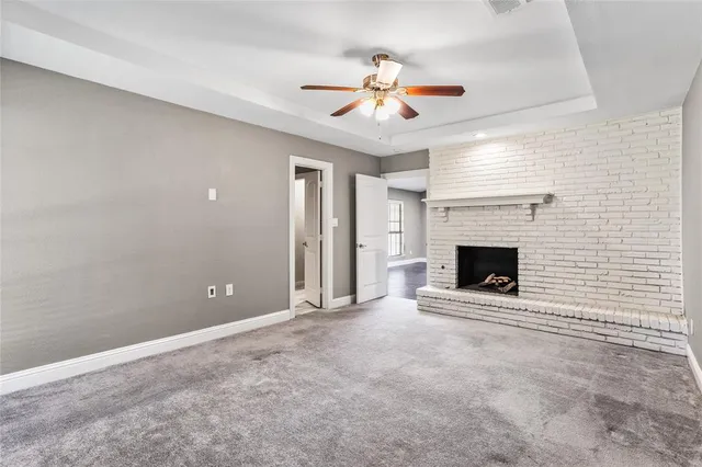 an empty room with fireplace and fan