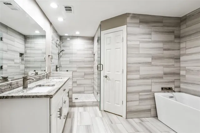 a bathroom with a granite countertop sink mirror and bathtub