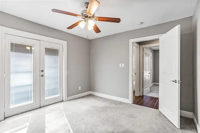 a view of a hallway with a chandelier fan and closet