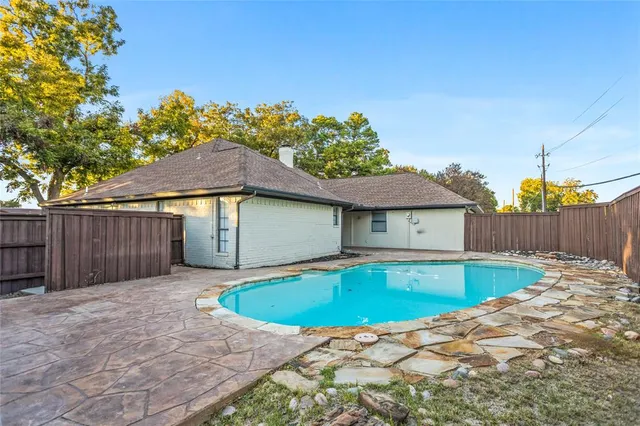 a view of a house with a swimming pool and a yard