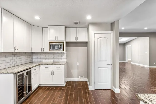 a kitchen with a refrigerator sink and cabinets